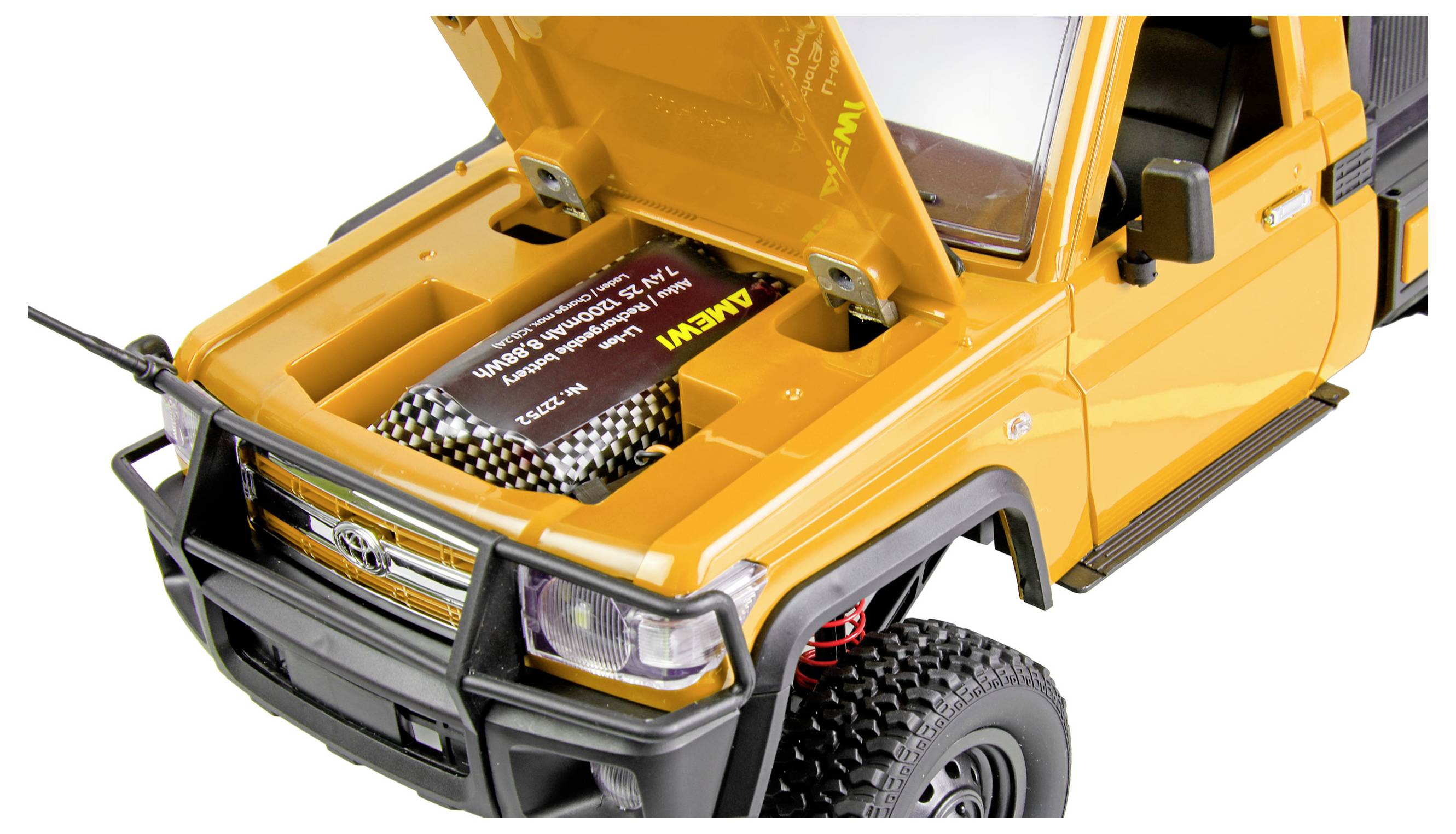 Véhicule RC tout-terrain jaune avec capot ouvert montrant le compartiment moteur, la calandre avant, le phare et un gros pneu à crampons.