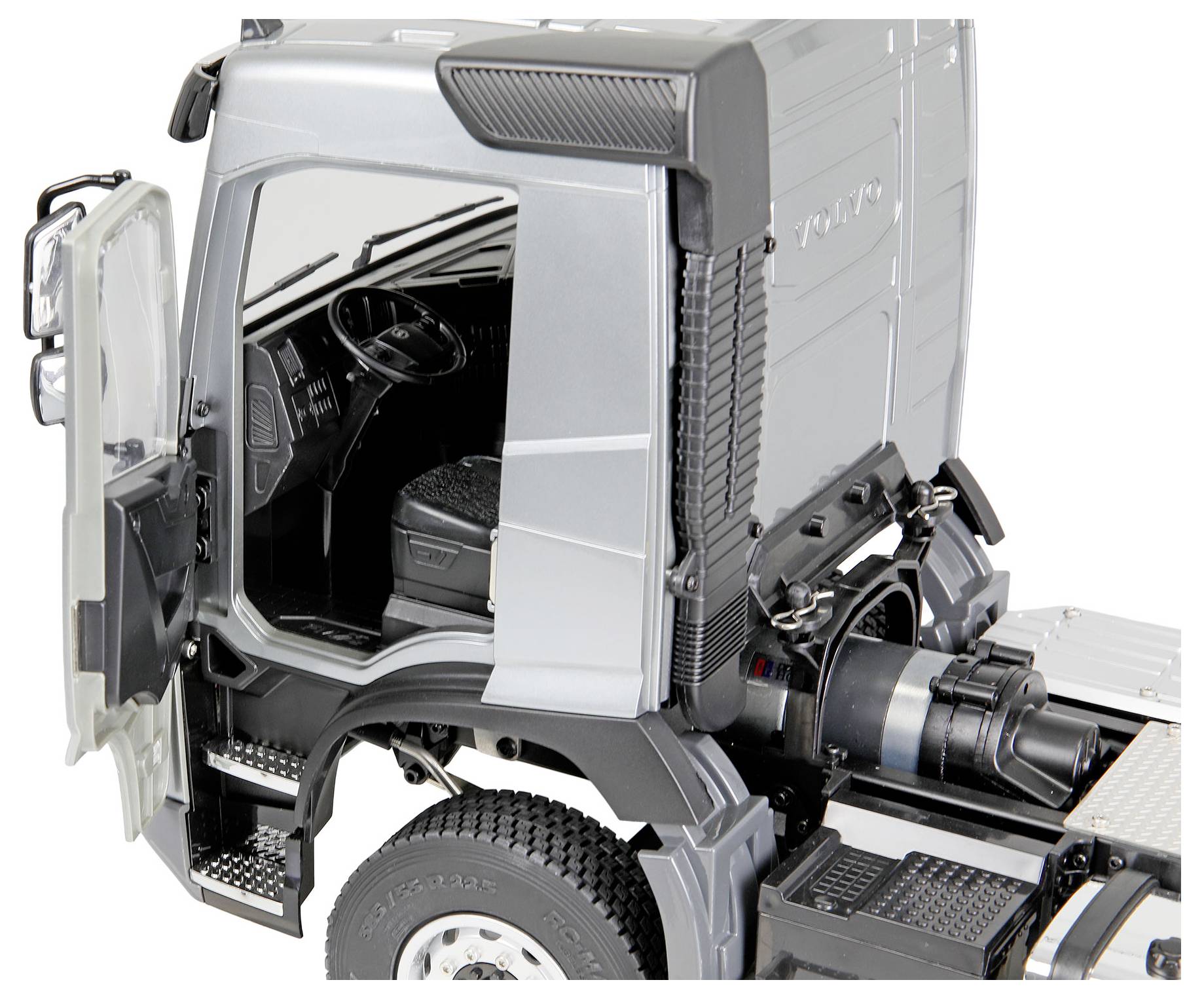 Vue en coupe d'une cabine de châssis de camion Volvo gris, montrant la porte ouverte, le siège du conducteur, le volant et les composants du moteur arrière exposés.
