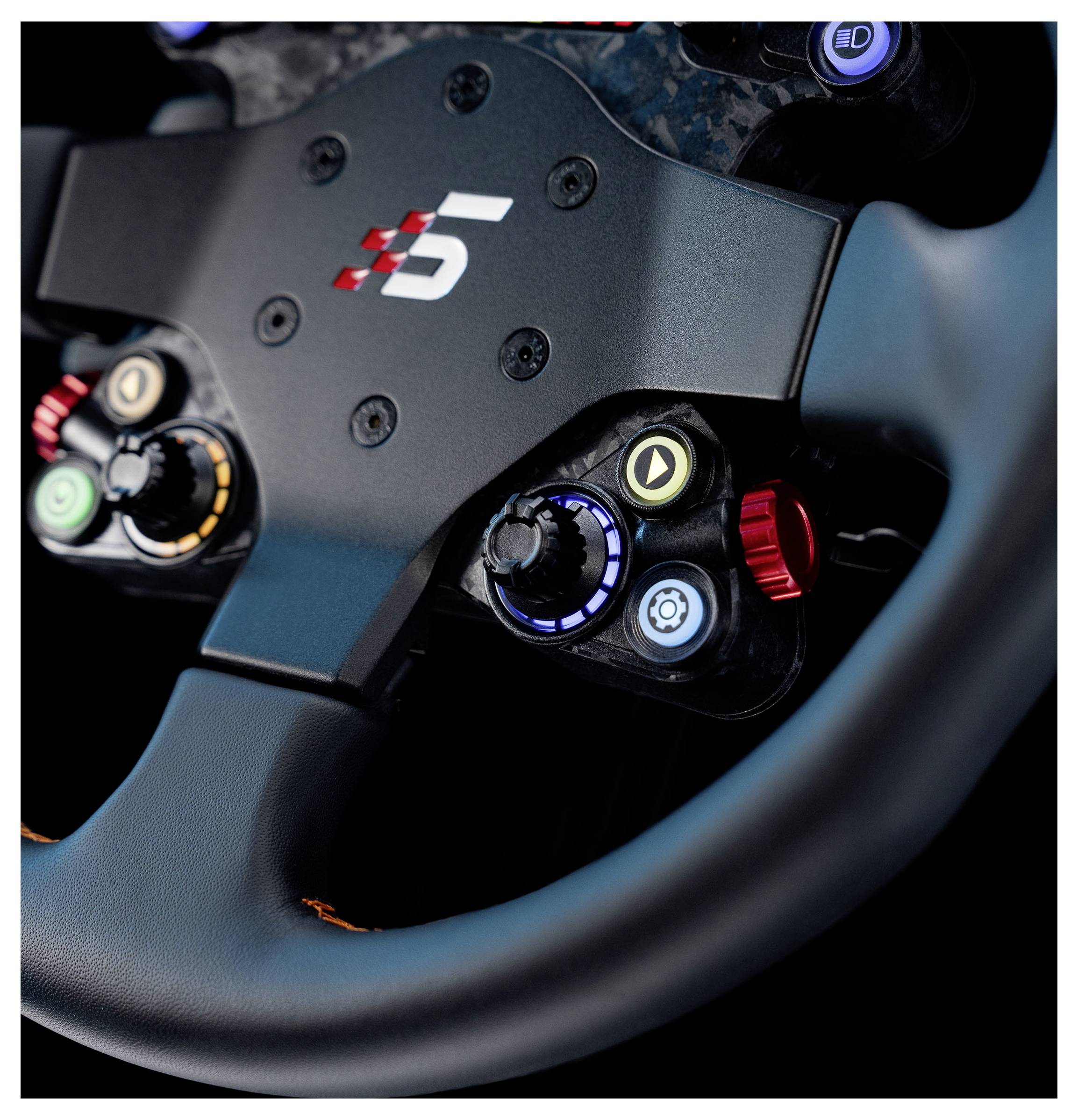 Gros plan d'un volant de style course avec plusieurs boutons et cadrans de commande, incluant un cadran bleu, un bouton rouge et des icônes de lecture et de vitesse.