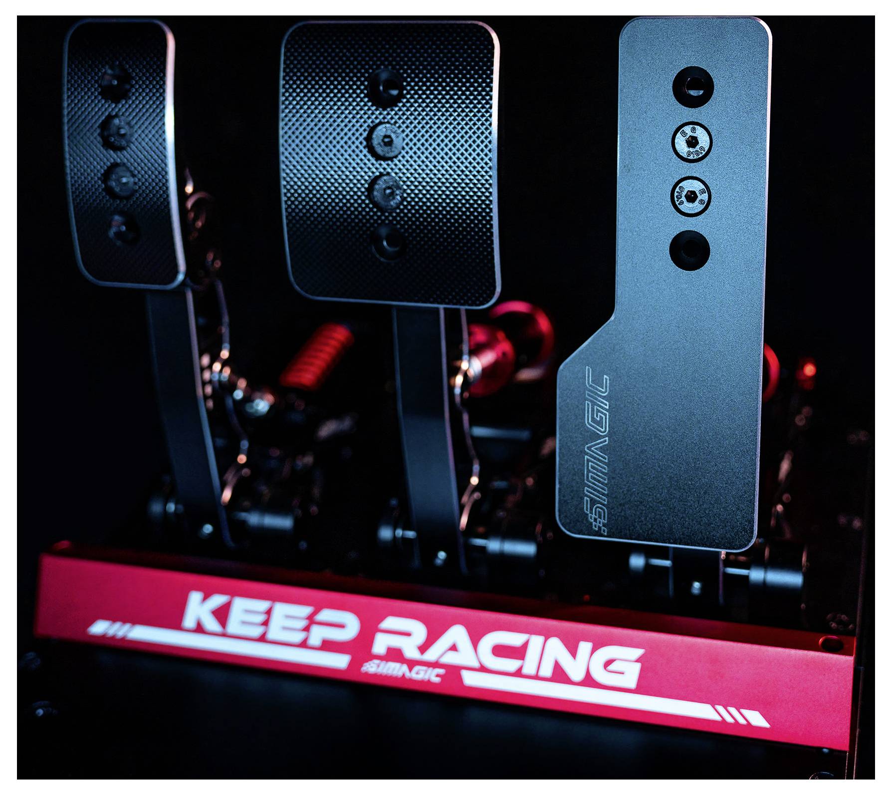 Gros plan d'un ensemble de pédales de simulateur de course avec trois pédales en métal et une base « KEEP RACING » illuminée en rouge.