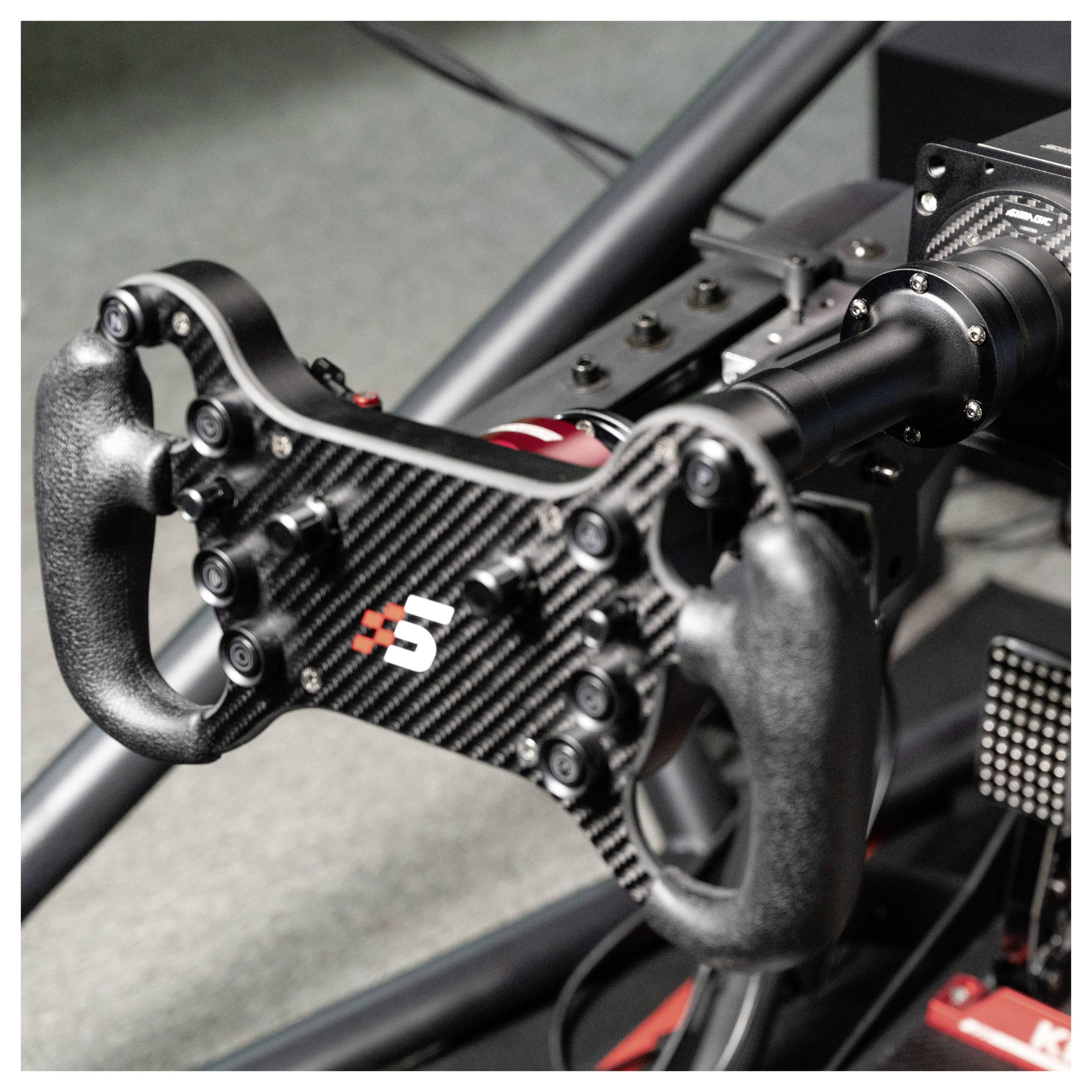 Gros plan d'un volant de course en fibre de carbone avec des poignées de paddle montées sur un simulateur ou un cockpit de voiture de course.