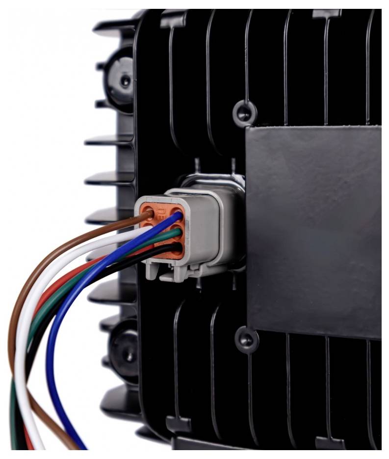Close-up of a black electronic device with a gray connector and multicolored wires plugged into it, showing a wired power/control connection.