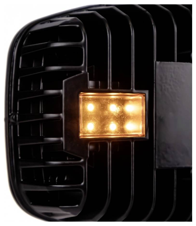 Close-up of a black car grille or vent with a glowing amber rectangular light in the center.