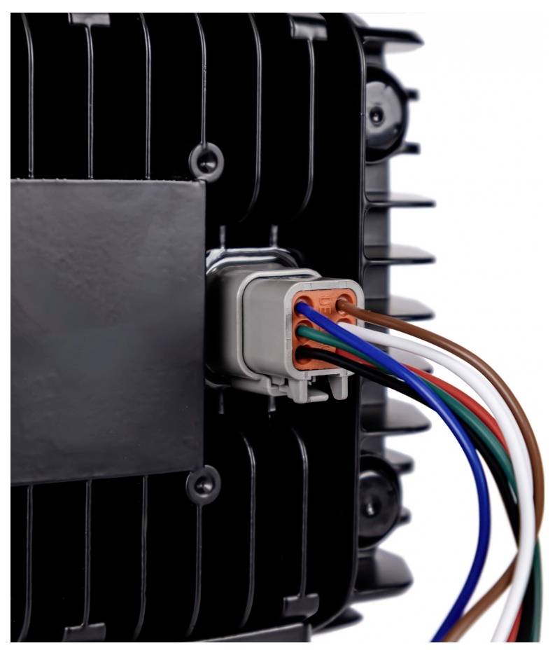 Close-up of a black electronic device with a multi-wire connector plugged into the side, showing colored wires extending outward.