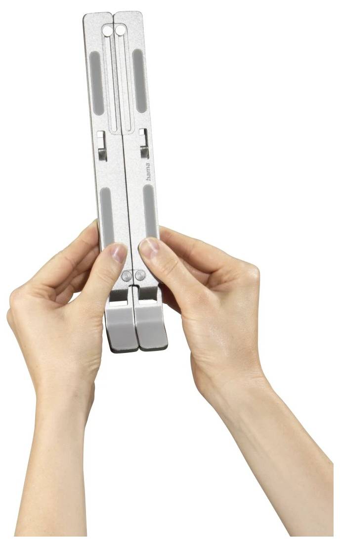 Des mains tenant un outil de mesure portatif gris plié avec deux moitiés articulées, présenté verticalement sur un fond blanc uni.