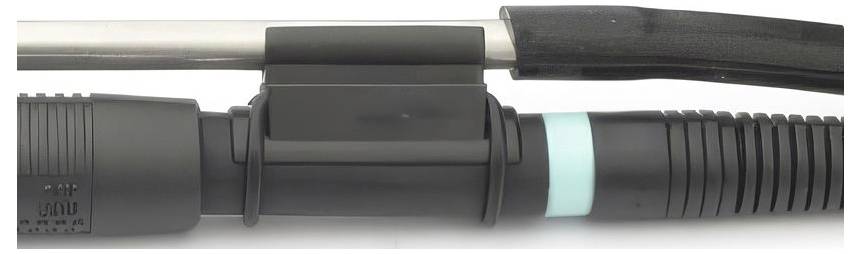 Gros plan d'un connecteur mécanique cylindrique noir ou d'une prise d'outil avec une tige argentée sur la gauche, une bague bleu clair et une poignée cannelée sur la droite.