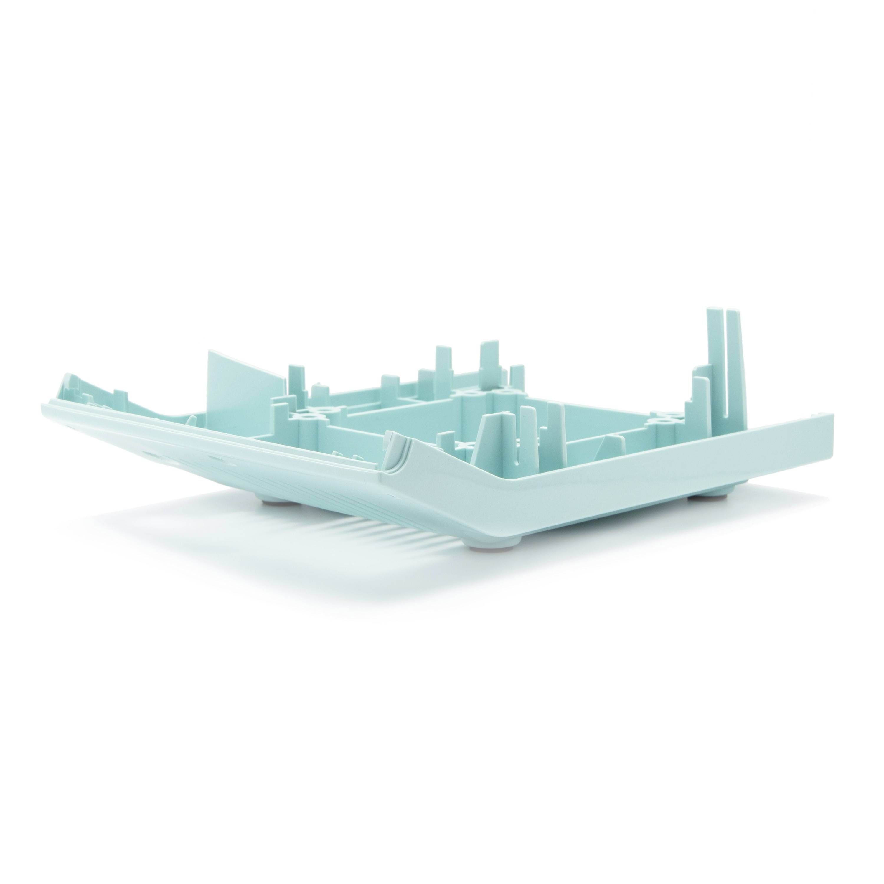 A turquoise 3D cityscape model inside a shallow tray, shown on a white background.