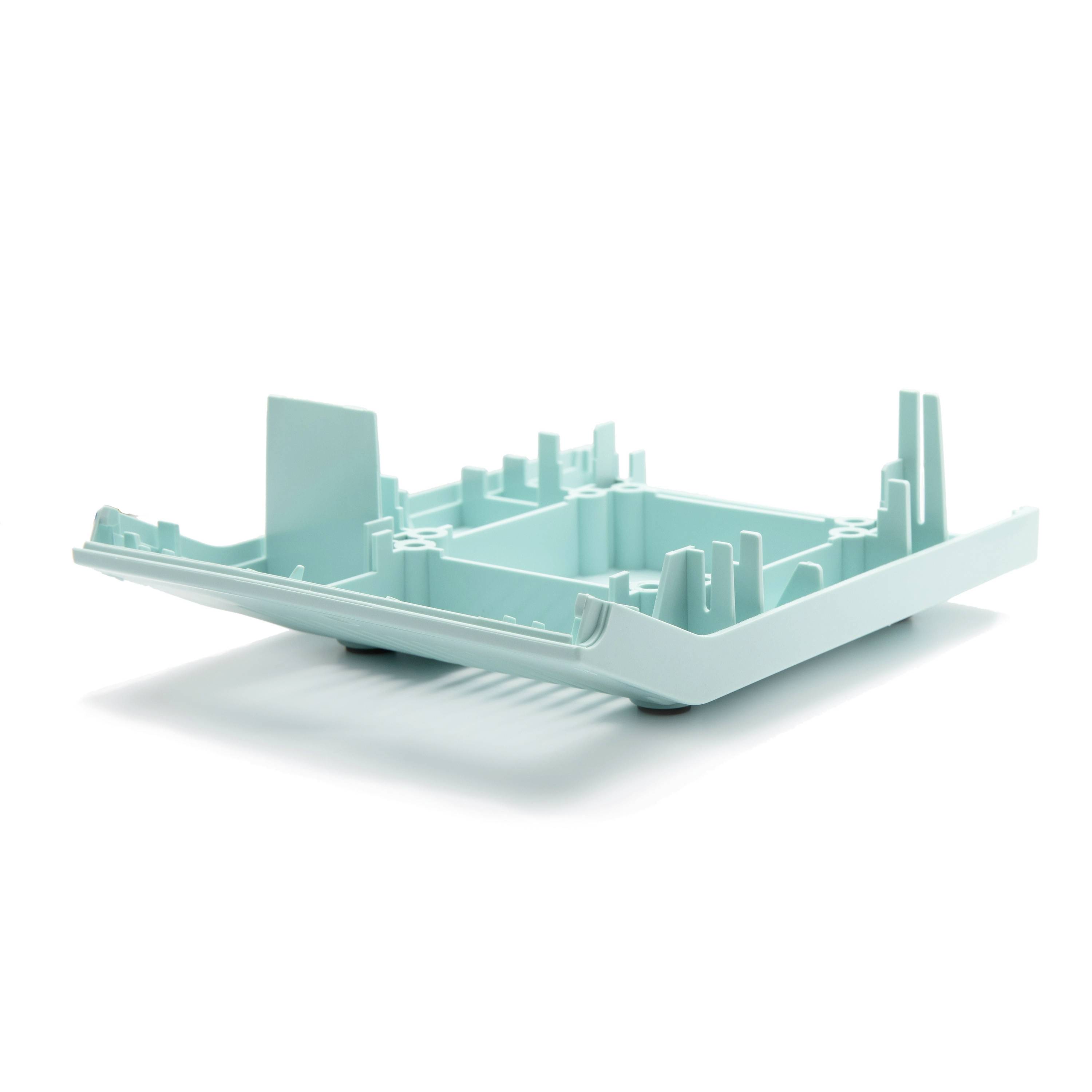 A turquoise 3D model of a city block or building site, shown as a low-relief architectural layout on a white background.