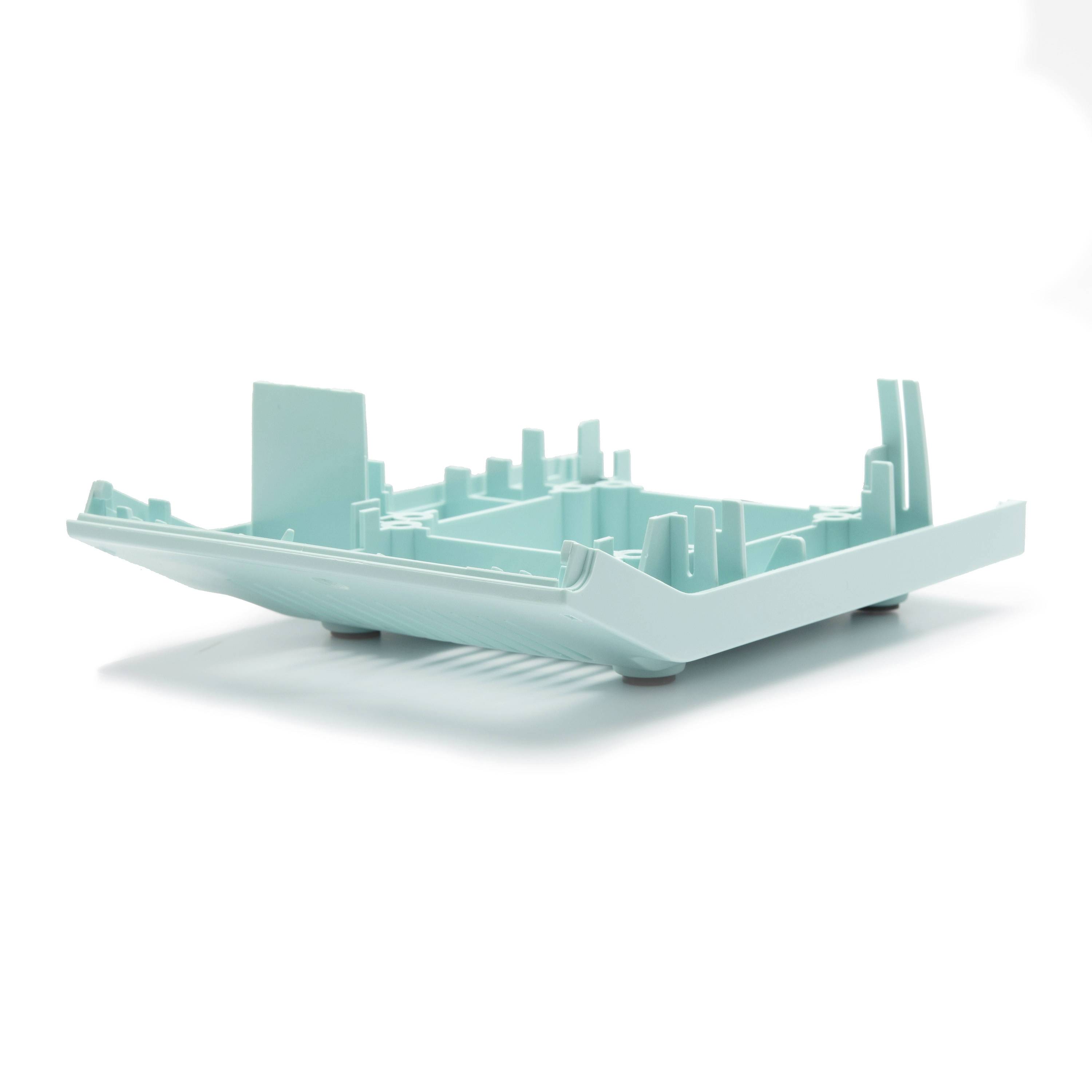 A mint-green plastic tray or organizer insert with molded compartments and raised edges, shown isolated on a white background.