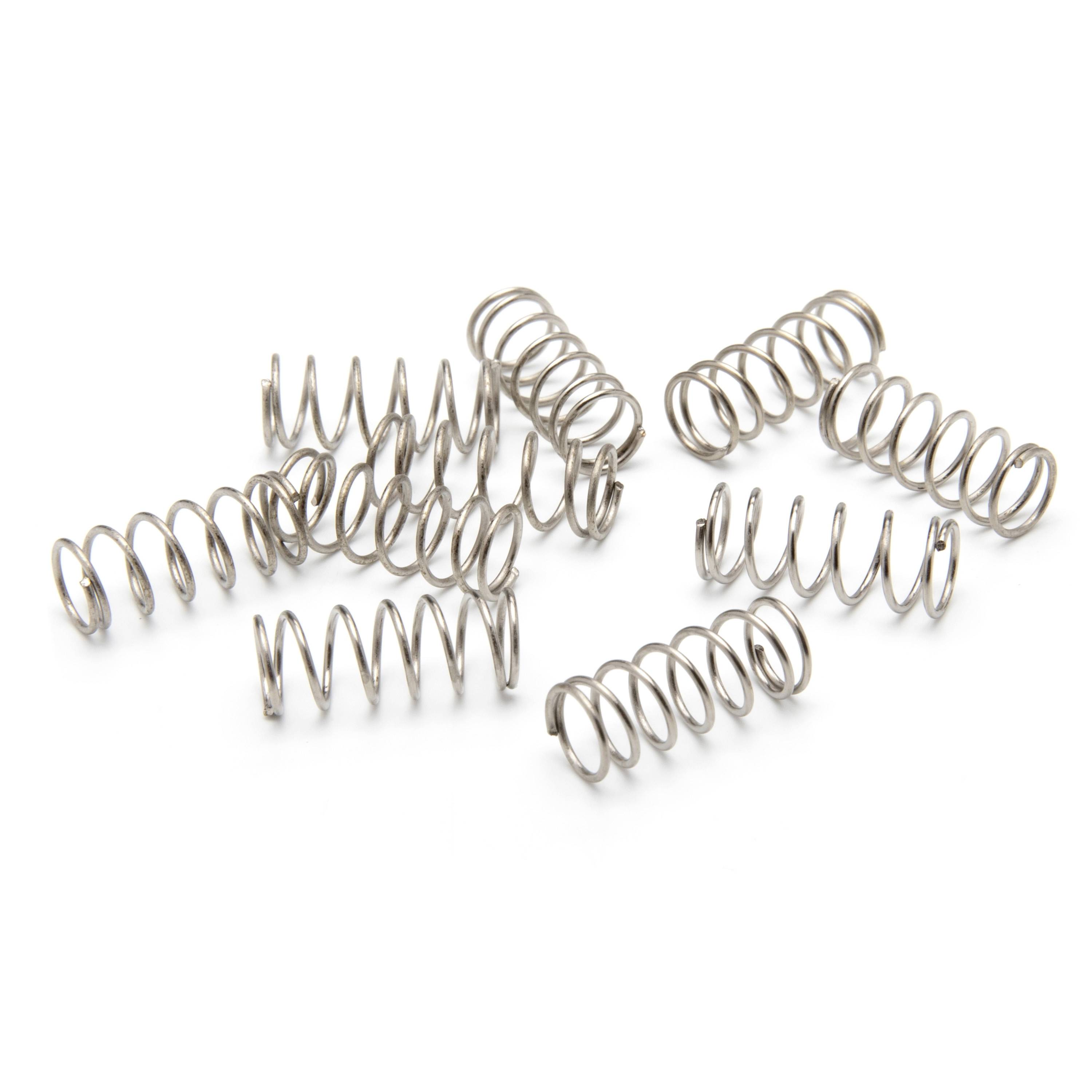 Assorted metal coil springs scattered on a white background.
