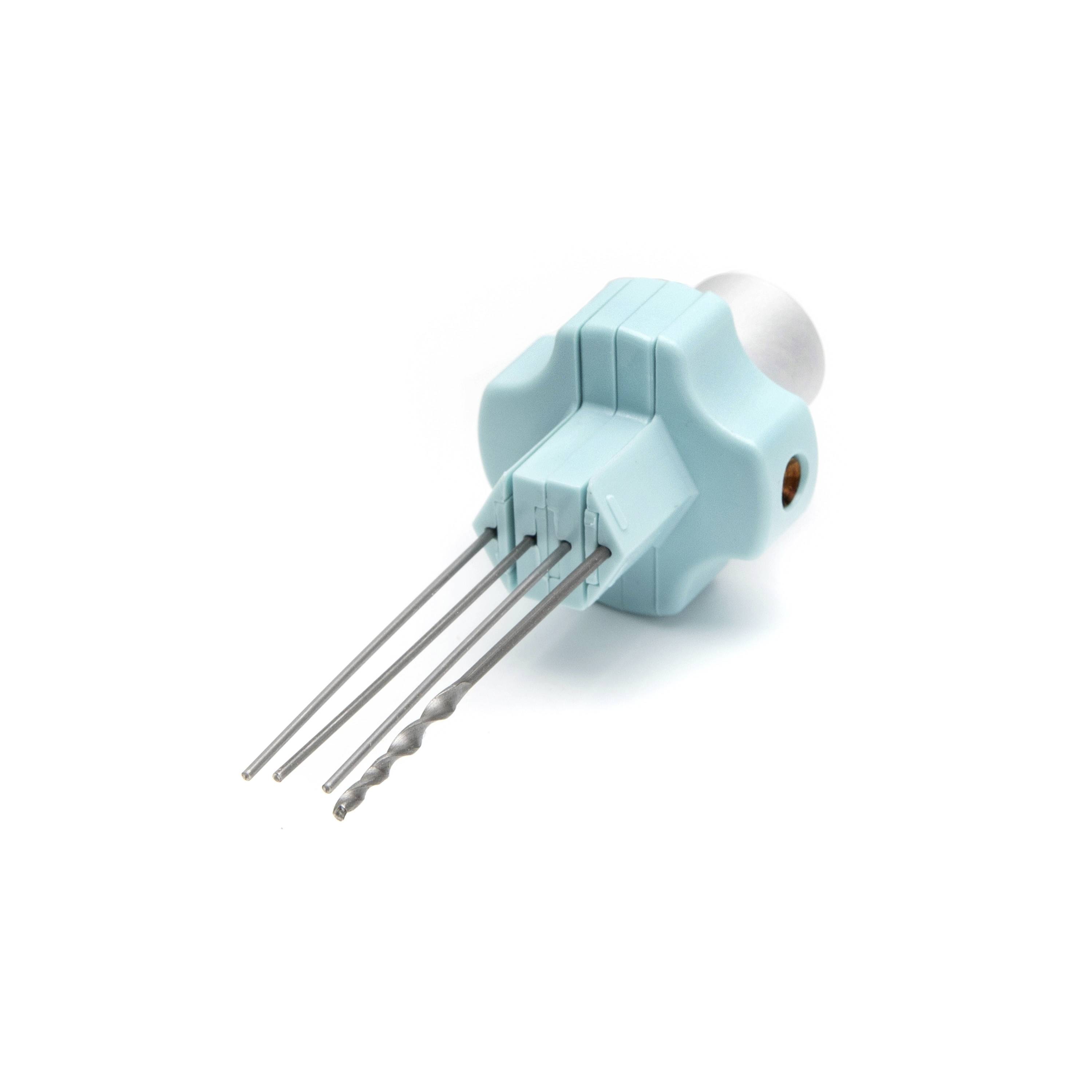 Small turquoise electronic component with four metal prongs and a silver end, isolated on a white background.