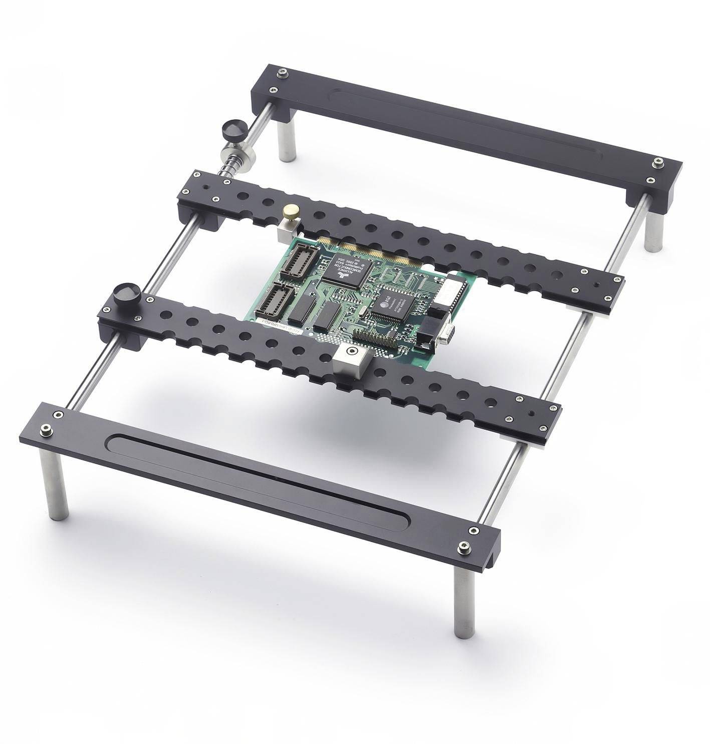 Electronic circuit board mounted in a black metal frame with adjustable rails and posts, shown on a white background.