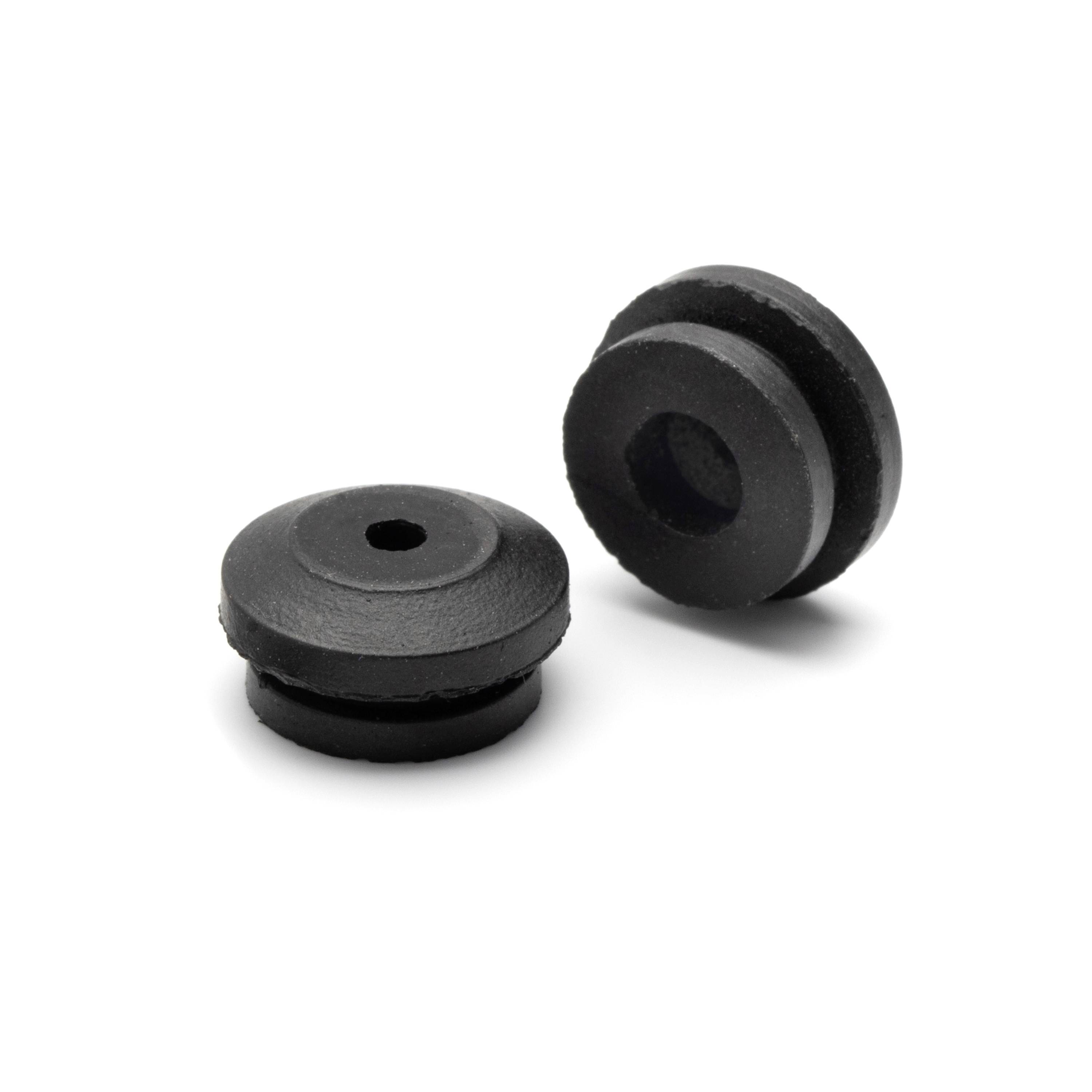 Two black rubber grommets or cable plugs on a white background, one lying flat and one standing upright.