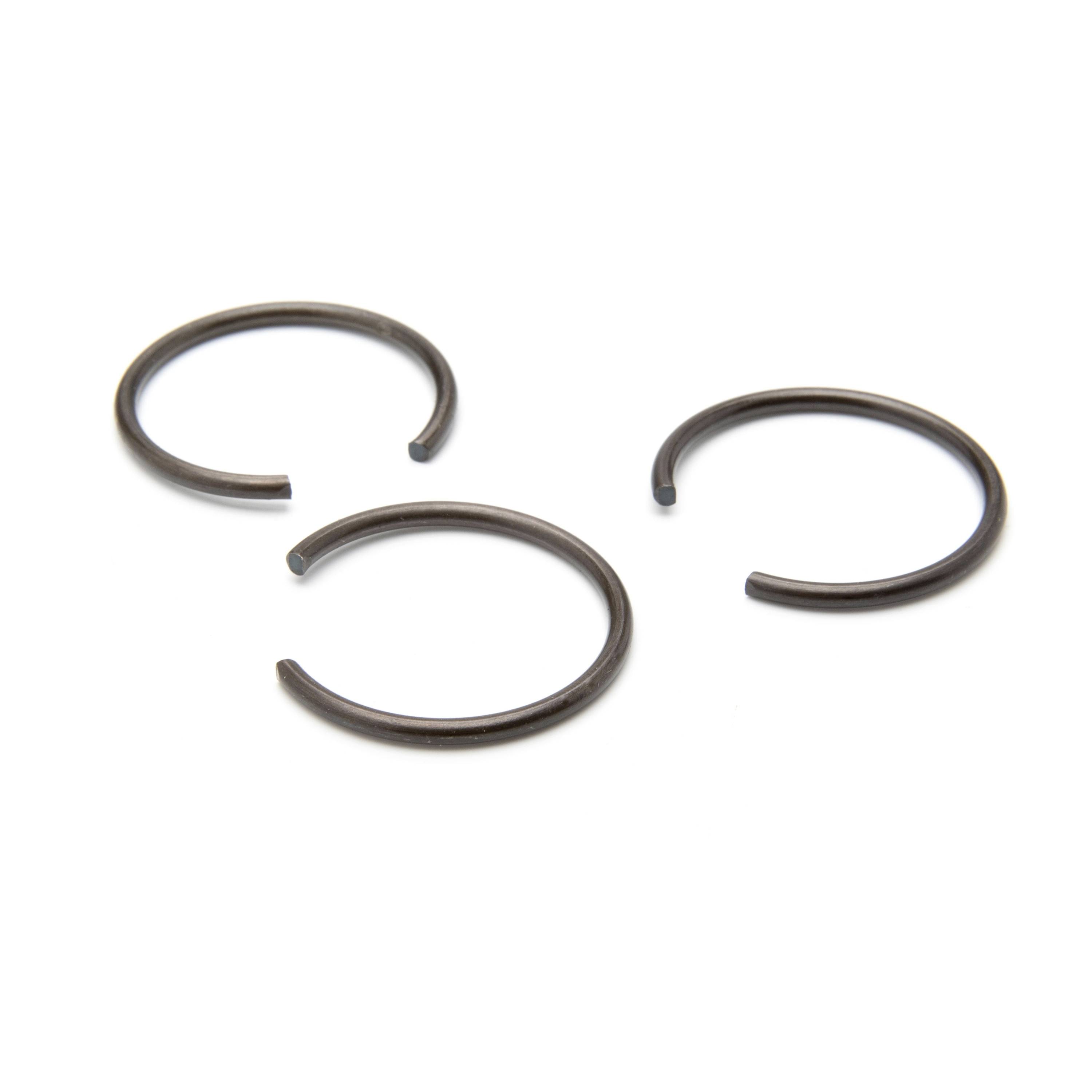 Three metal split retaining rings arranged on a white background.