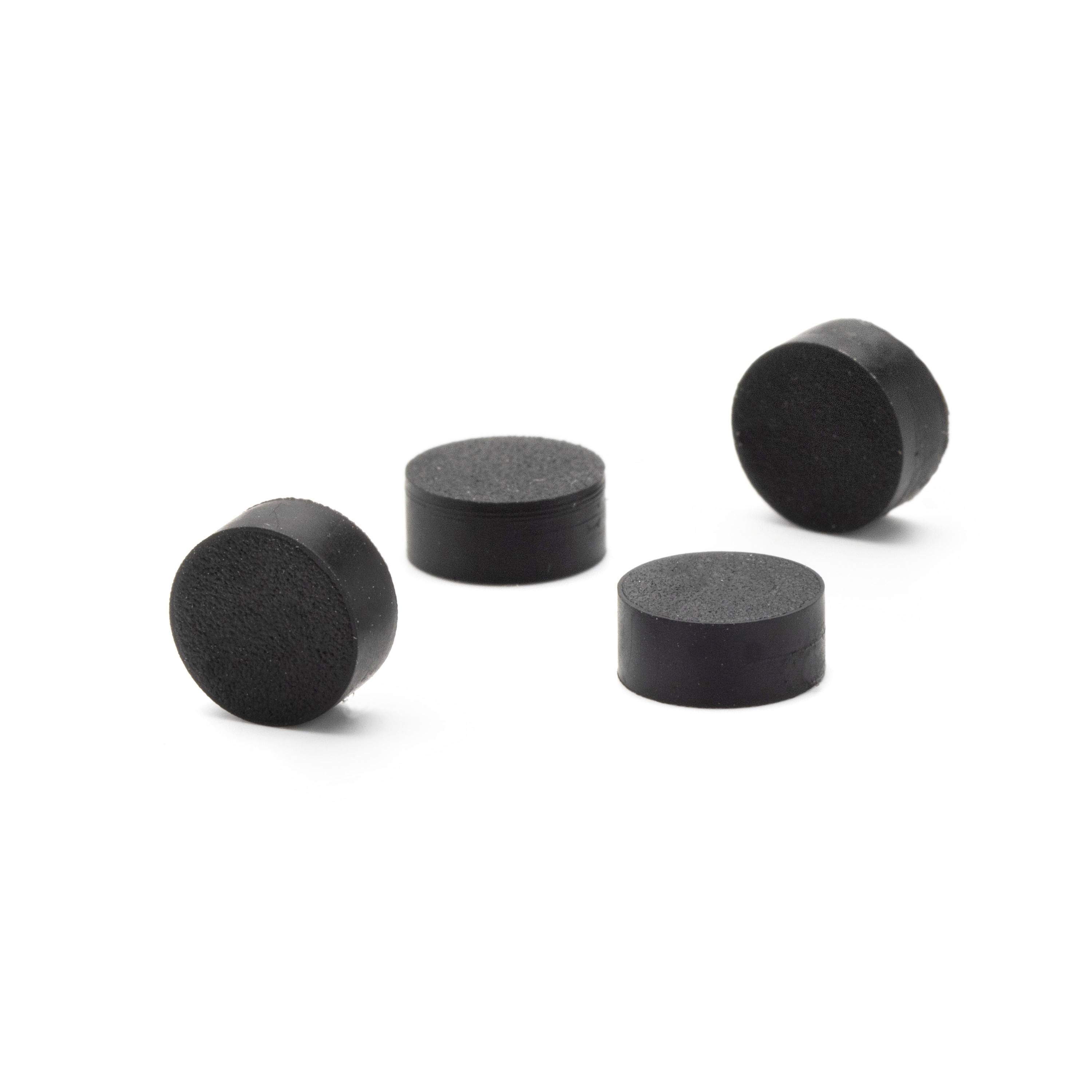 Four small black cylindrical pads or spacers arranged on a white background.