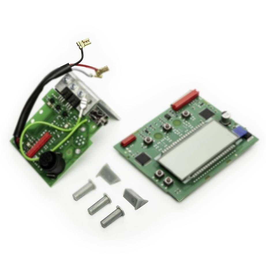 Two green electronic circuit boards with connectors and a display, plus three small metal standoffs on a white background.