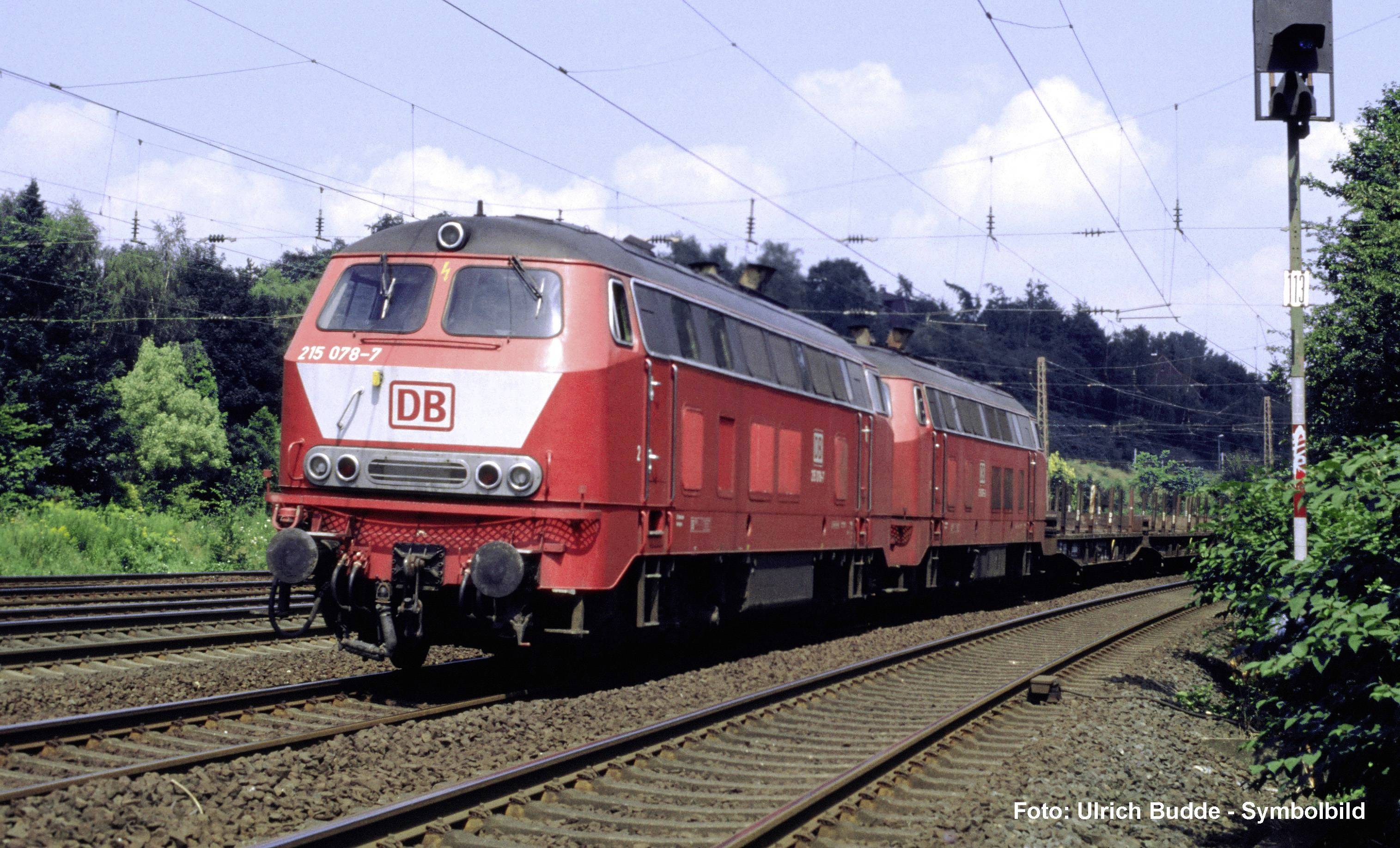 Locomotive de fret BLUE PRESS numérotée 285 102-4 sur les voies à côté d'un bâtiment industriel, vue de l'avant-gauche.