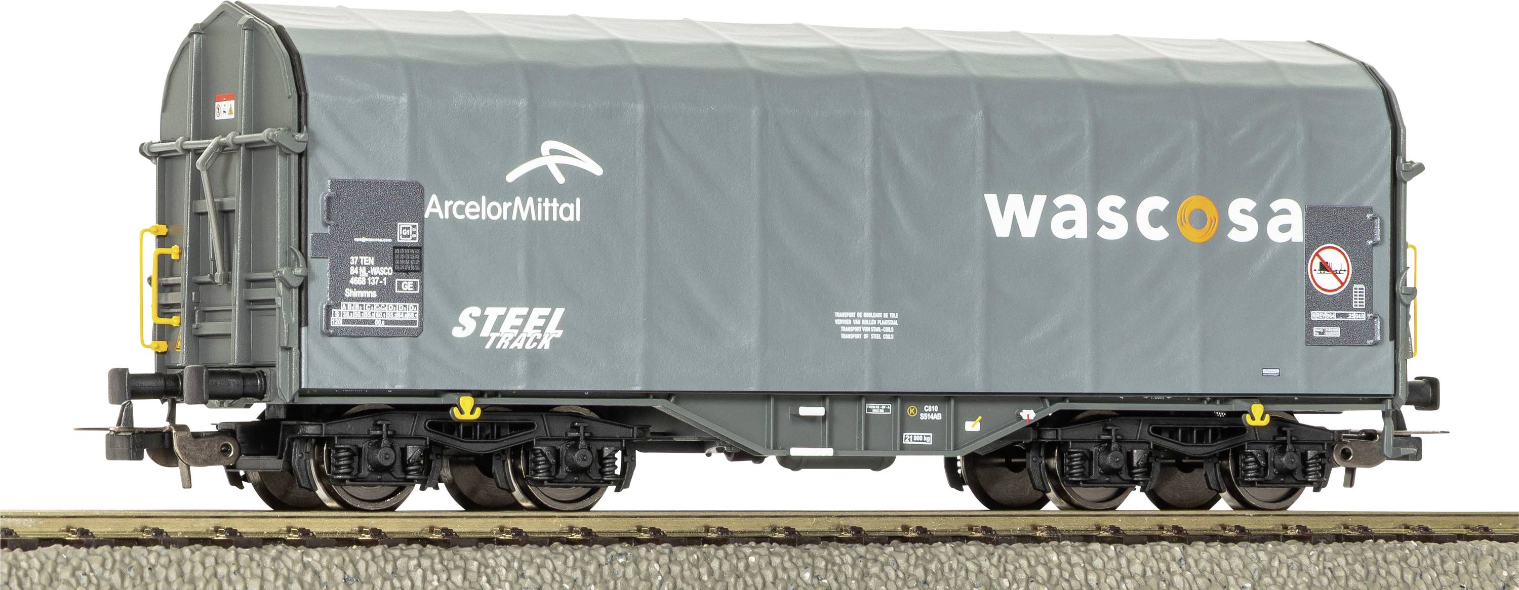 Vue de côté d'un wagon de fret couvert vert avec les logos « wascosa » et « ArcelorMittal » sur les rails.