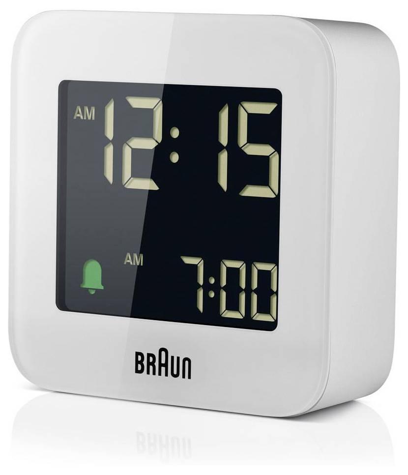 Réveil numérique blanc Braun affichant 12:15 AM et une alarme programmée pour 7:00 AM, avec une icône de cloche verte sur l'écran.