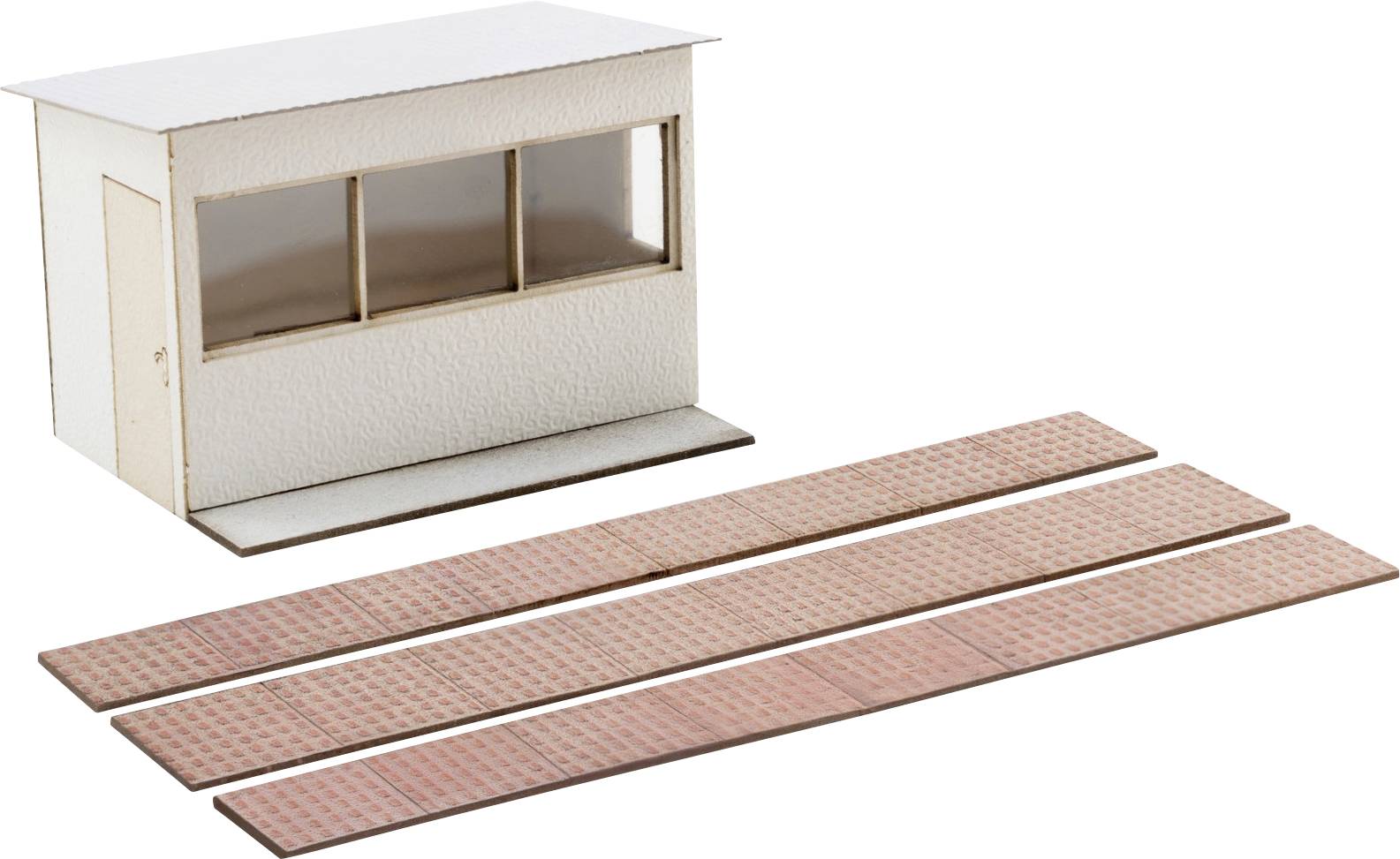 Kit de construction de modèle avec une petite structure blanche et quatre longues bandes de base imprimées disposées à côté.