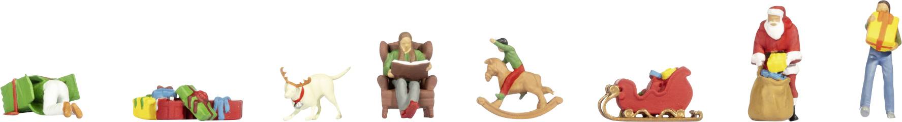 Une rangée de petites figurines à thème de Noël : des cadeaux, un chien, une personne assise, un cheval à bascule, le Père Noël dans un traîneau, le Père Noël avec un sac, et une personne debout.