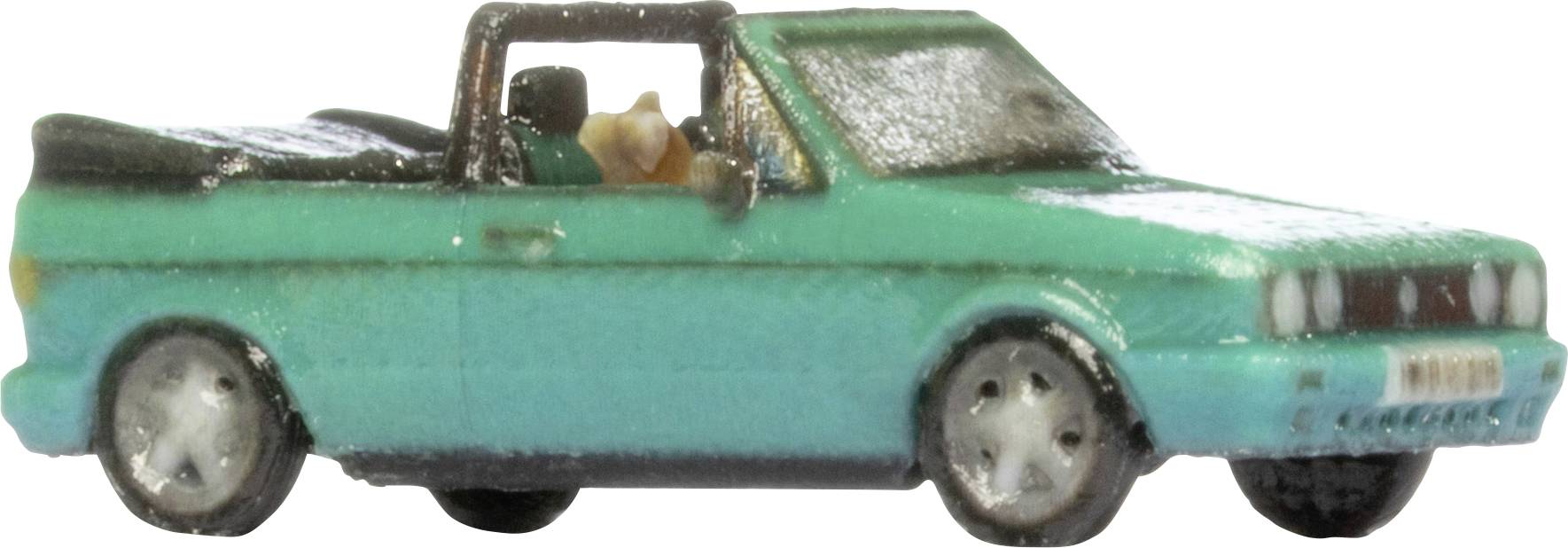 Camion de jouet turquoise montré en vue de côté sur un fond blanc uni.