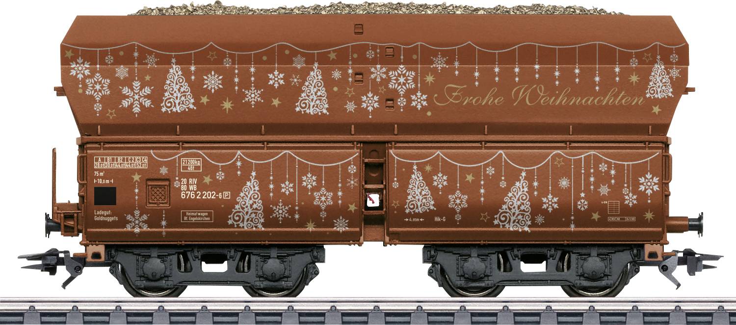 Vue latérale d'un wagon-trémie de marchandises brun décoré de sapins de Noël blancs et de flocons de neige, avec « Frohe Weihnachten » écrit sur le côté.