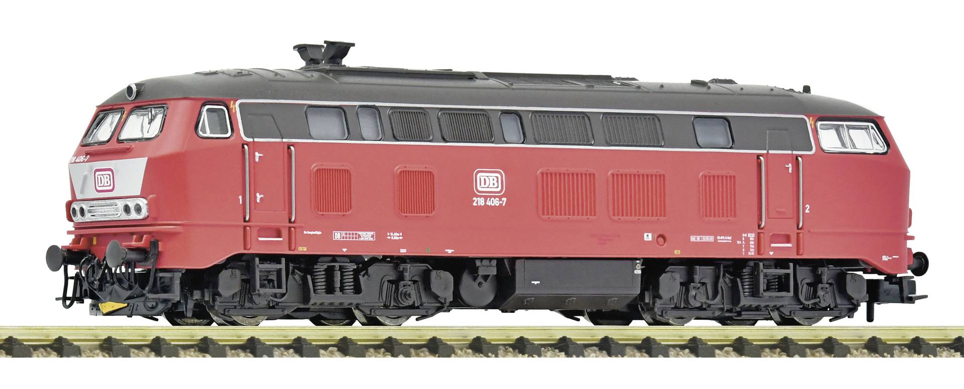 Vue latérale d'une locomotive à vapeur noire et rouge sur les rails, montrant son moteur, ses grandes roues et son tender attaché.