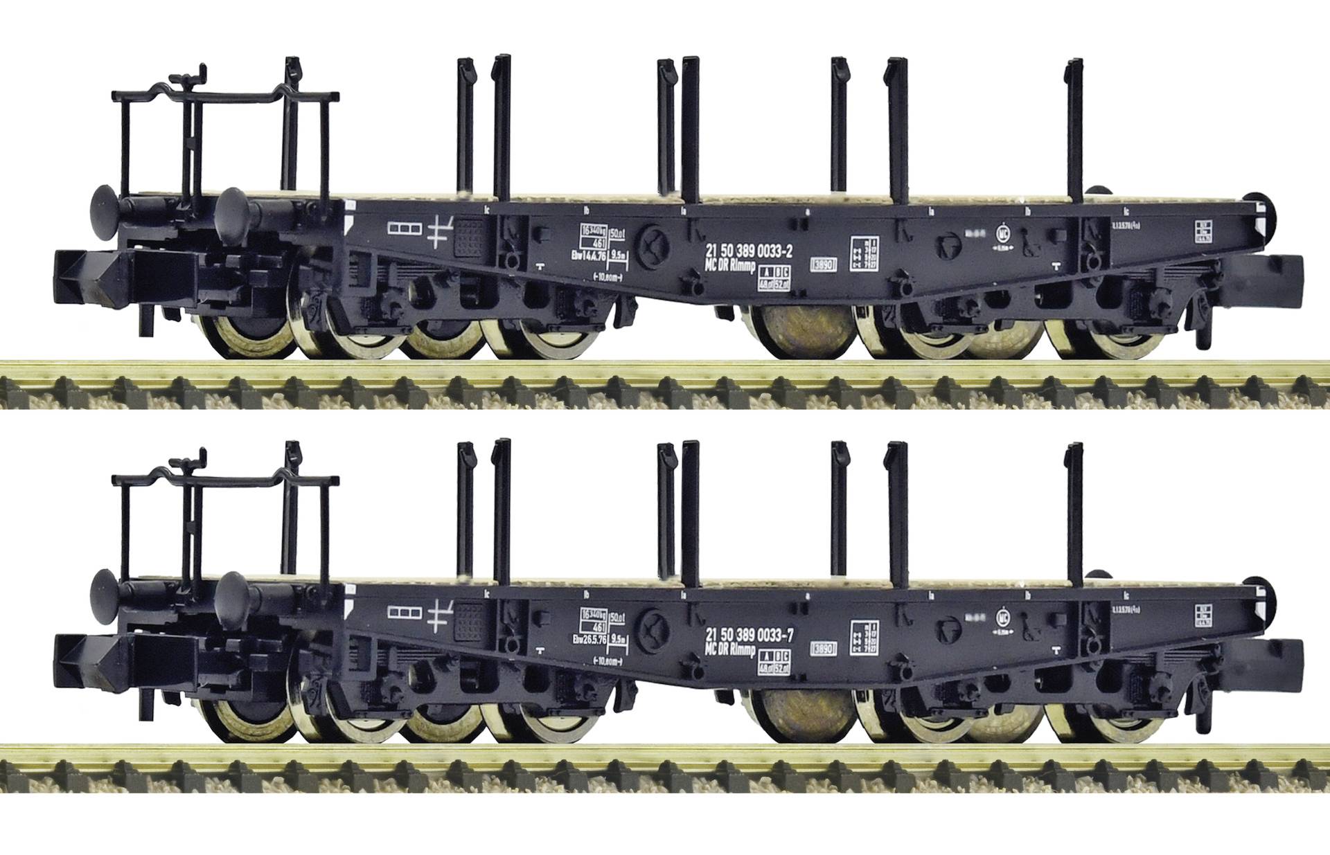 Two identical black flatbed railcars on tracks, shown side by side, with upright stake posts and couplers visible.
