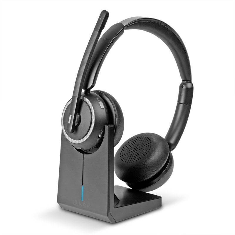 Casque sans fil supra-auriculaire noir avec microphone sur socle de charge.