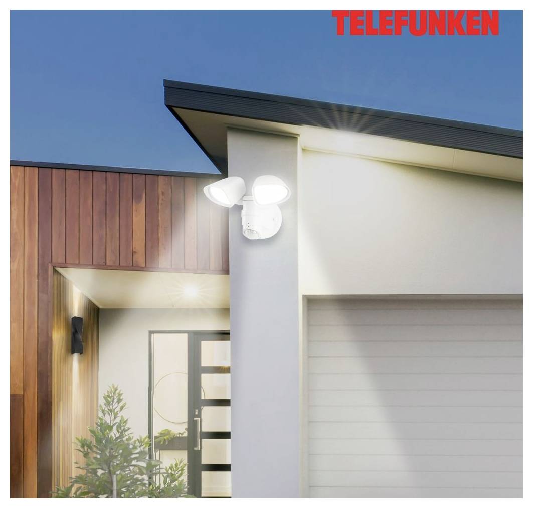 Telefunken outdoor security light mounted on a modern house exterior, illuminating the entryway and garage at dusk.