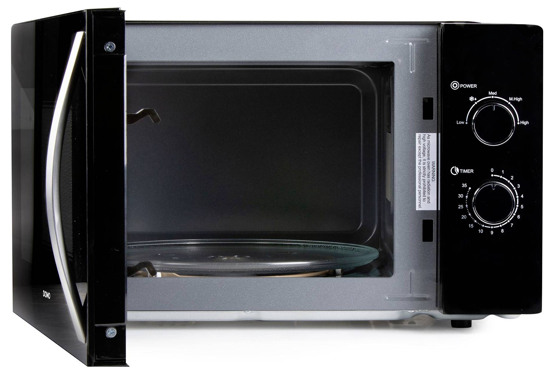 Open black countertop microwave oven with the door ajar, showing an empty glass turntable inside and two control dials on the right