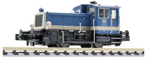 Locomotive-tender modèle bleu et noir sur des rails de chemin de fer, vue de côté sur fond blanc.