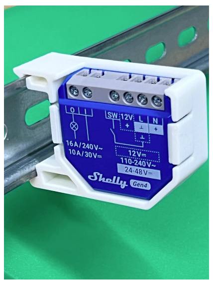 Module relais intelligent Shelly Gen4 monté sur un rail DIN, étiqueté avec des bornes de câblage et des évaluations de tension pour le contrôle électrique domestique.