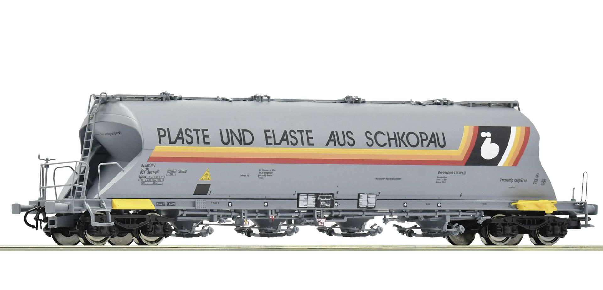 Wagon de fret sauterelle gris étiqueté « PLASTE UND ELASTE AUS SCHKOPAU » avec des graphiques à bandes rouges, orange et jaunes.