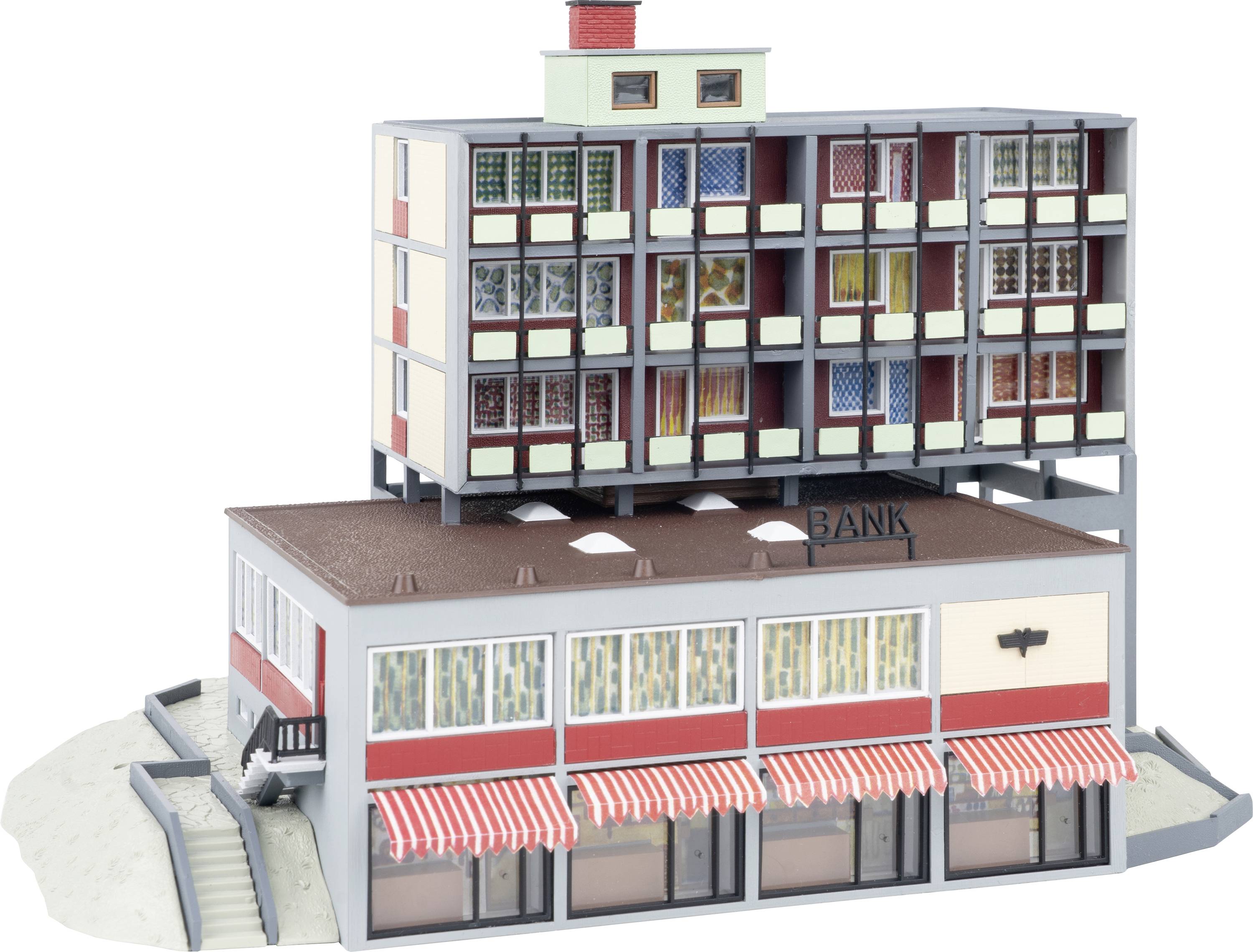 Un modèle d'un petit bâtiment bancaire avec des auvents rayés, surmonté d'un immeuble d'appartements multi-étages, présenté comme une maquette architecturale.