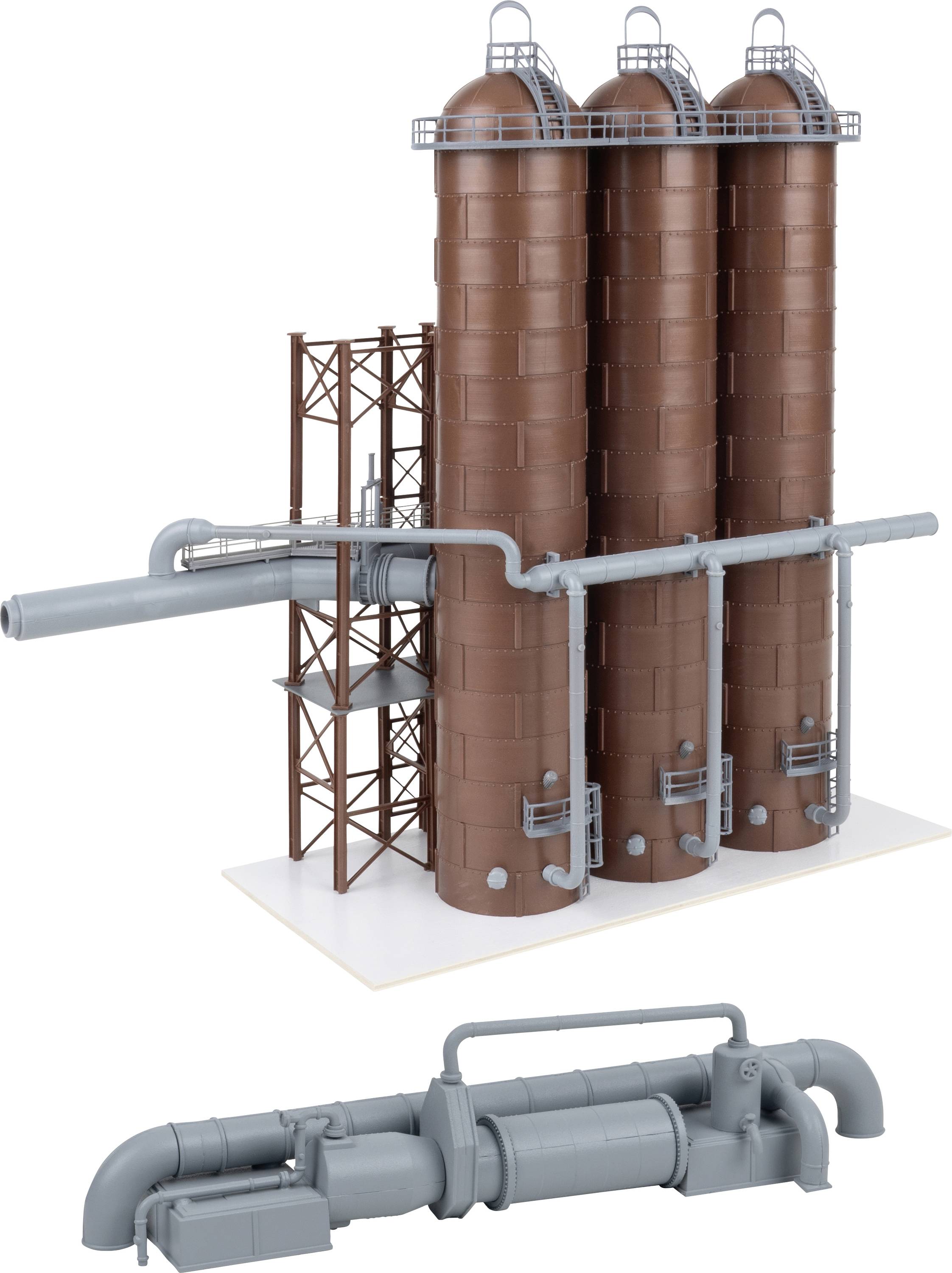 Complexe de silo à grains industriel avec trois grands silos de stockage bruns reliés par des tuyaux métalliques et une unité de convoyage/traitement en dessous.