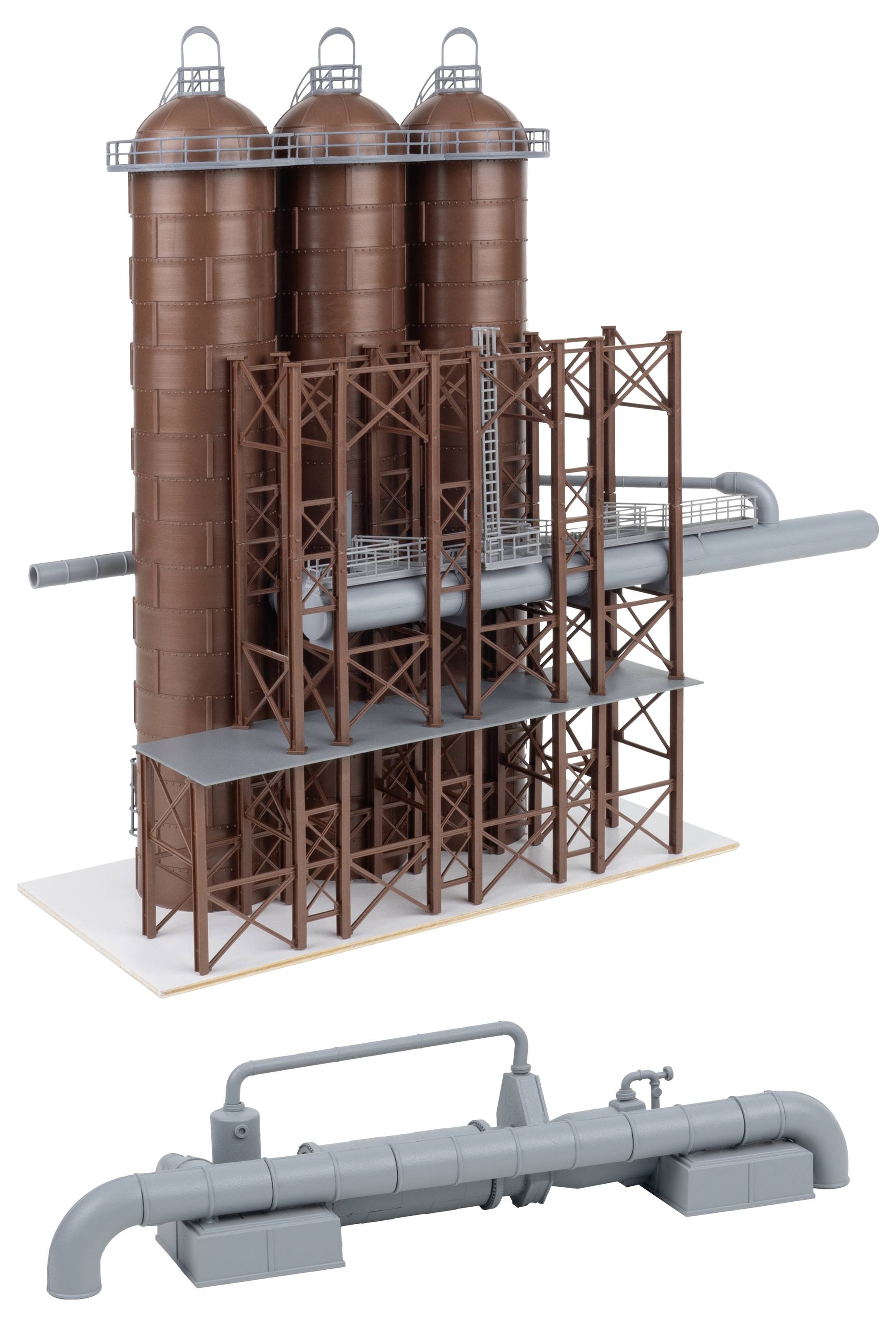 Illustration d'équipement industriel montrant trois hauts silos marron sur une structure de support en acier avec tuyauterie grise connectée, plus un ensemble de tuyauterie séparé ci-dessous.
