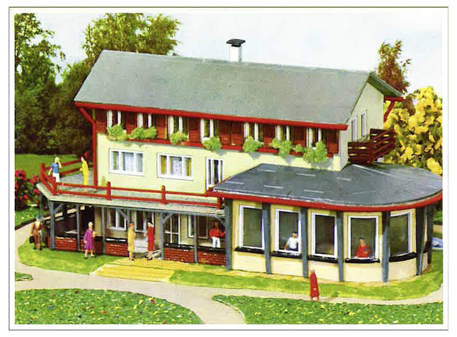 Maquette d'une maison sur deux étages avec des garnitures rouges, une véranda enveloppante et une véranda solarium attenante, présentée à l'extérieur avec de petites figurines pour donner l'échelle.
