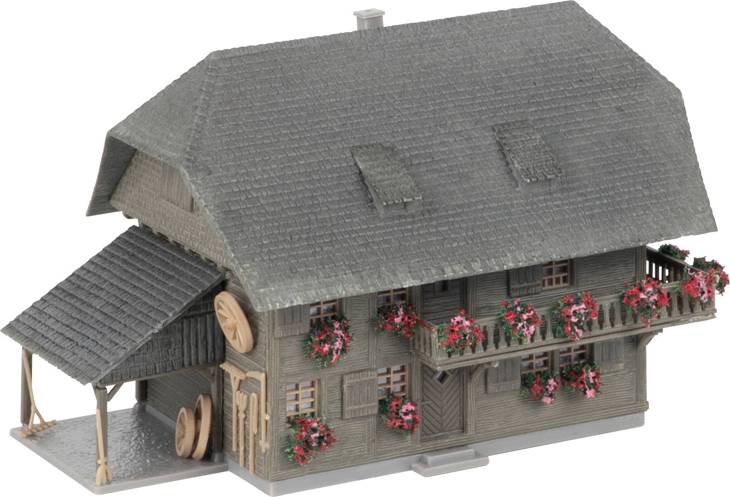 Modèle de maison de style alpin en bois avec un toit gris escarpé, des jardinières et un petit abri latéral.