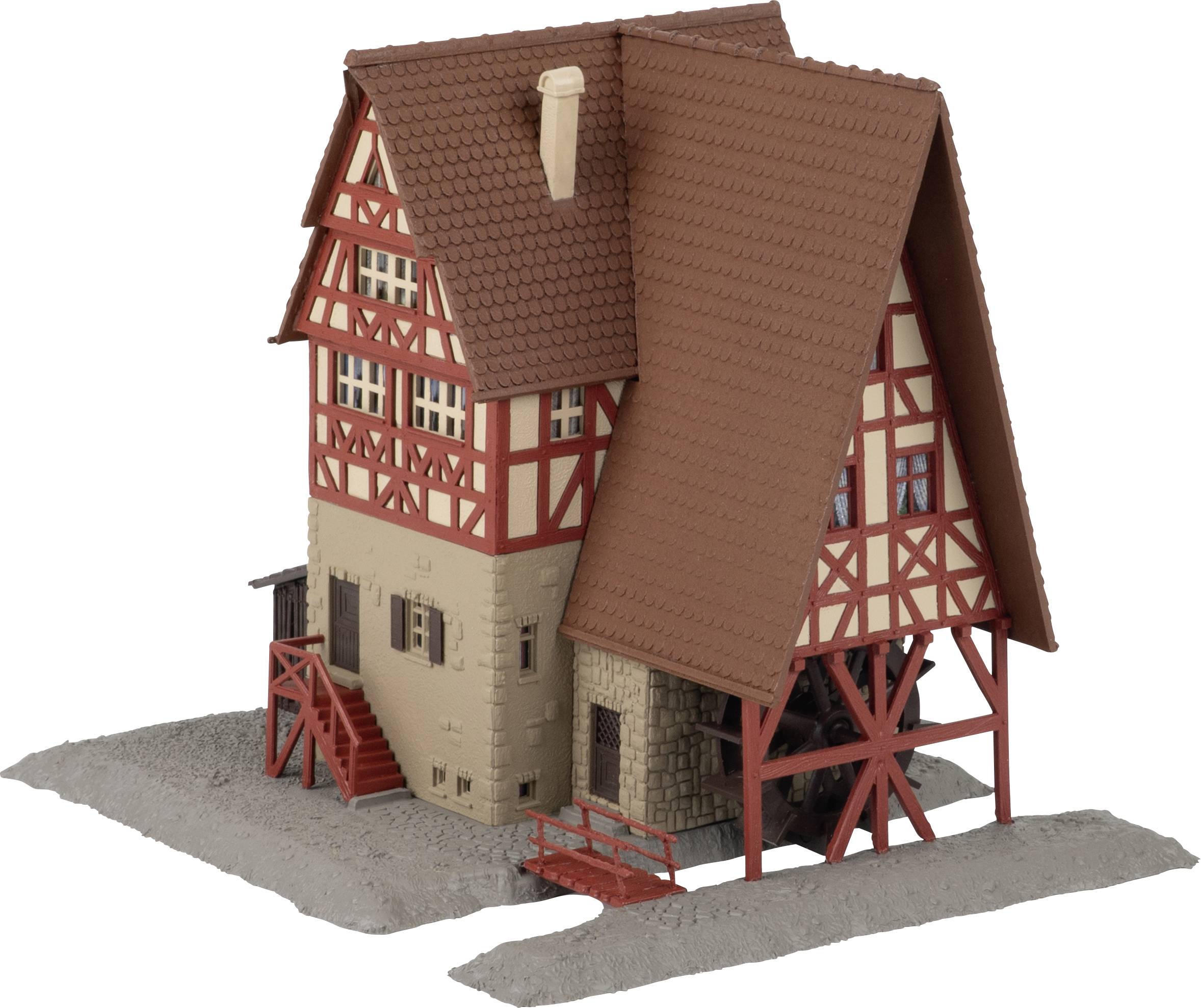 Un modèle détaillé d'une maison à colombages avec un toit brun abrupt, un encadrement de bois rouge, une base en pierre et un petit escalier extérieur sur une base grise.