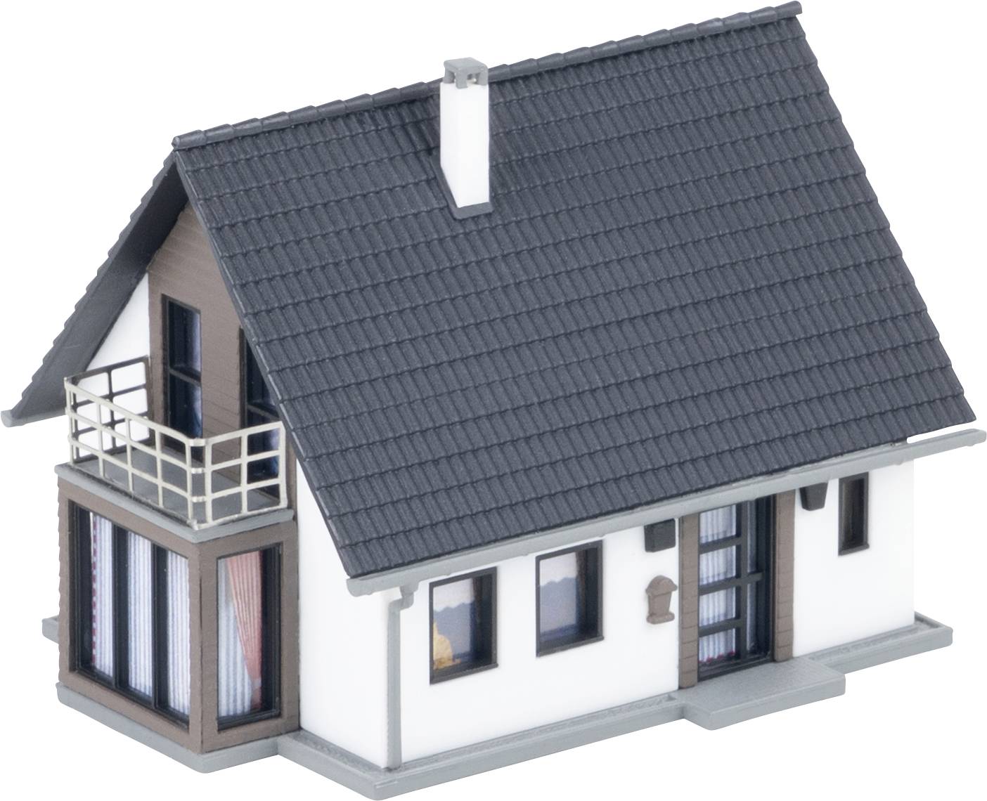 Un petit modèle de maison moderne avec un toit en tuiles gris foncé, des murs blancs, un balcon et plusieurs fenêtres, présenté sur un fond neutre.