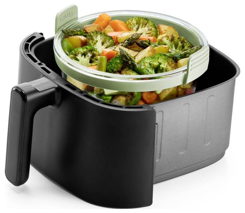 Panier de friteuse à air avec un plateau rond de légumes rôtis, montrant l'appareil utilisé pour la cuisson ou le réchauffage des aliments.