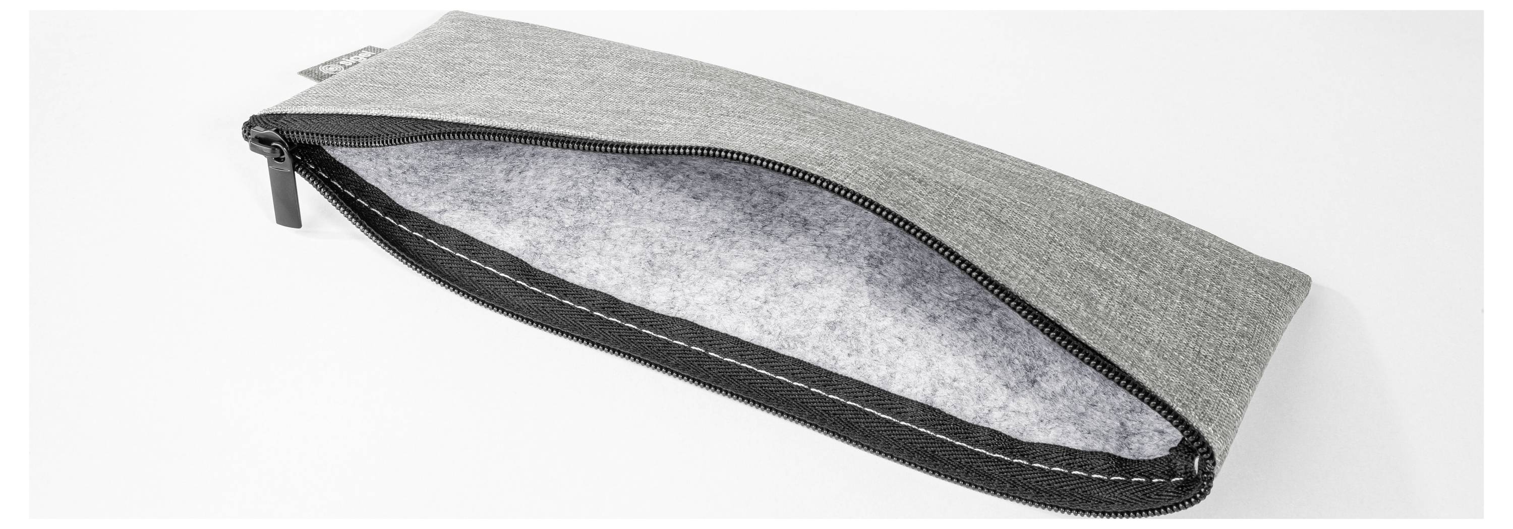 Pochette grise avec fermeture éclair noire, partiellement ouverte pour révéler un intérieur doublé de tissu gris clair.