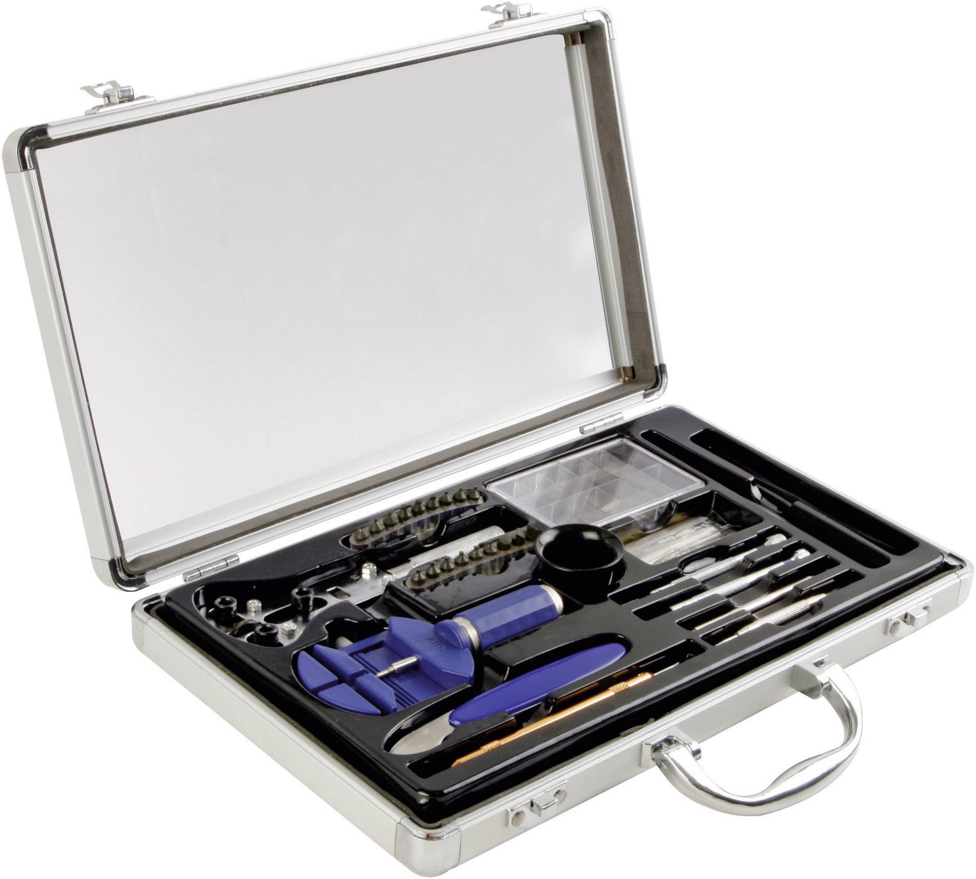 Une boîte à outils ouverte contenant divers outils, notamment des vis, des forets et un tournevis, posée sur une table.