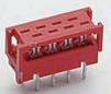 Fiche électrique rouge à broches métalliques multiples, adaptée aux connexions de circuits imprimés. Se caractérise par sa forme rectangulaire.