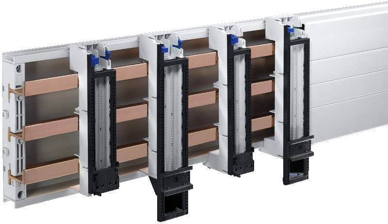 Une barre omnibus avec quatre disjoncteurs modulaires montre le câblage interne et les conducteurs en cuivre. Adaptée aux applications industrielles.