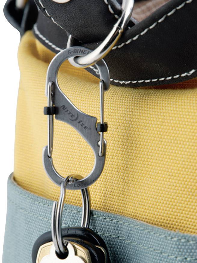 Un mousqueton argenté relie un sac jaune et un sac bleu. Un porte-clés avec une clé y est accroché.