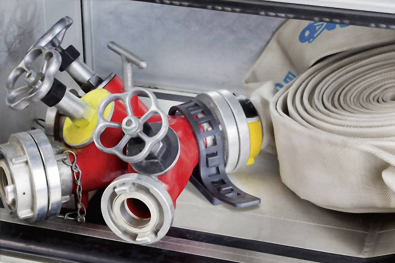 Tuyaux de pompiers et vannes dans une armoire. Outils principaux pour combattre les incendies et réguler l'eau, soigneusement rangés.