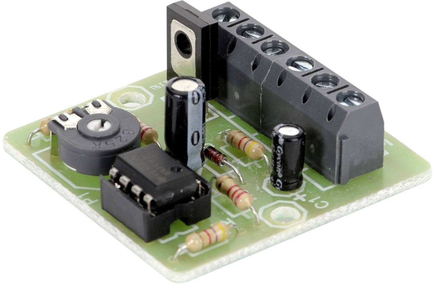 Une carte électronique verte avec des résistances, des condensateurs, une puce à circuit intégré et des blocs de terminaux.